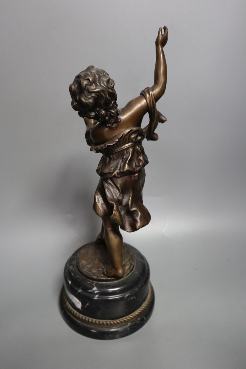 A pair of late 19th century painted bronze labourer figures after Debut, 12in., and a bronze figure of a playful girl, on marble plinth